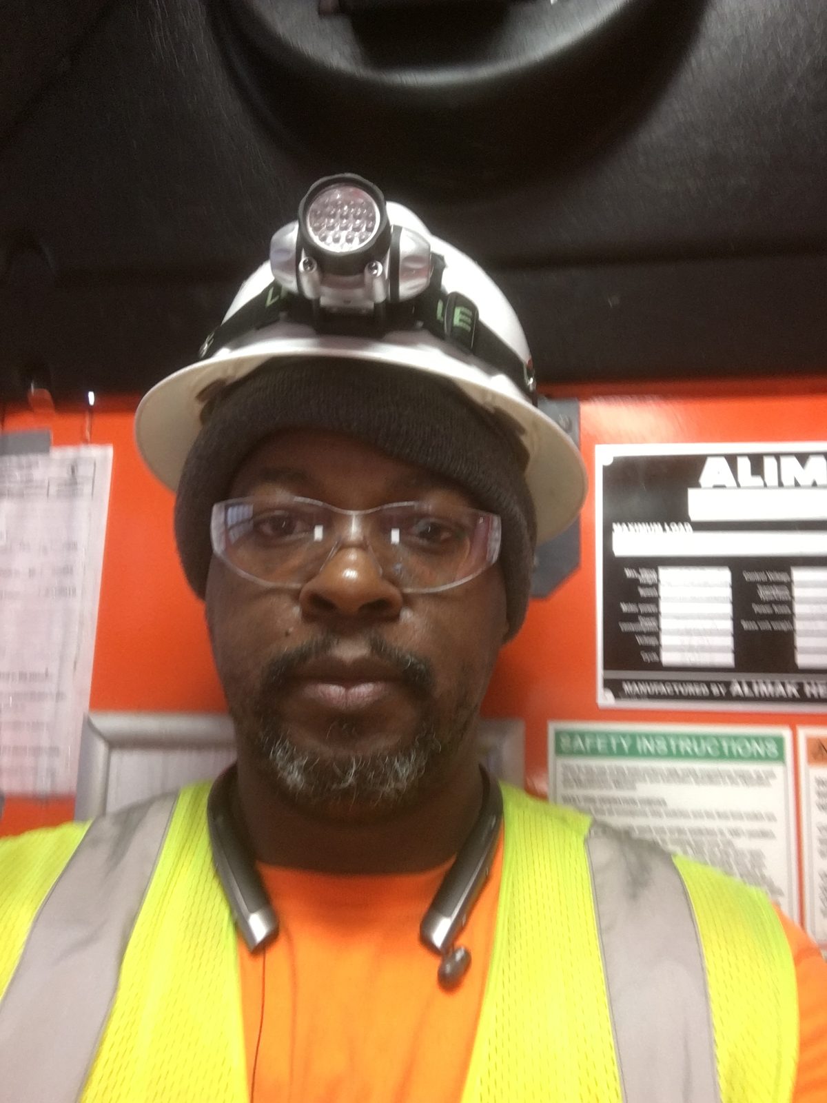 Amos Ross III on the job in a hard hat, headlamp, and hi-vis
