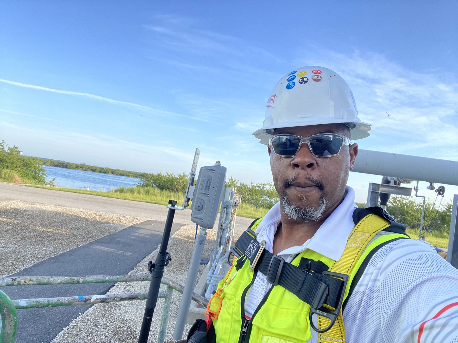 Amos Ross III servicing outdoor wireless equipment by the water