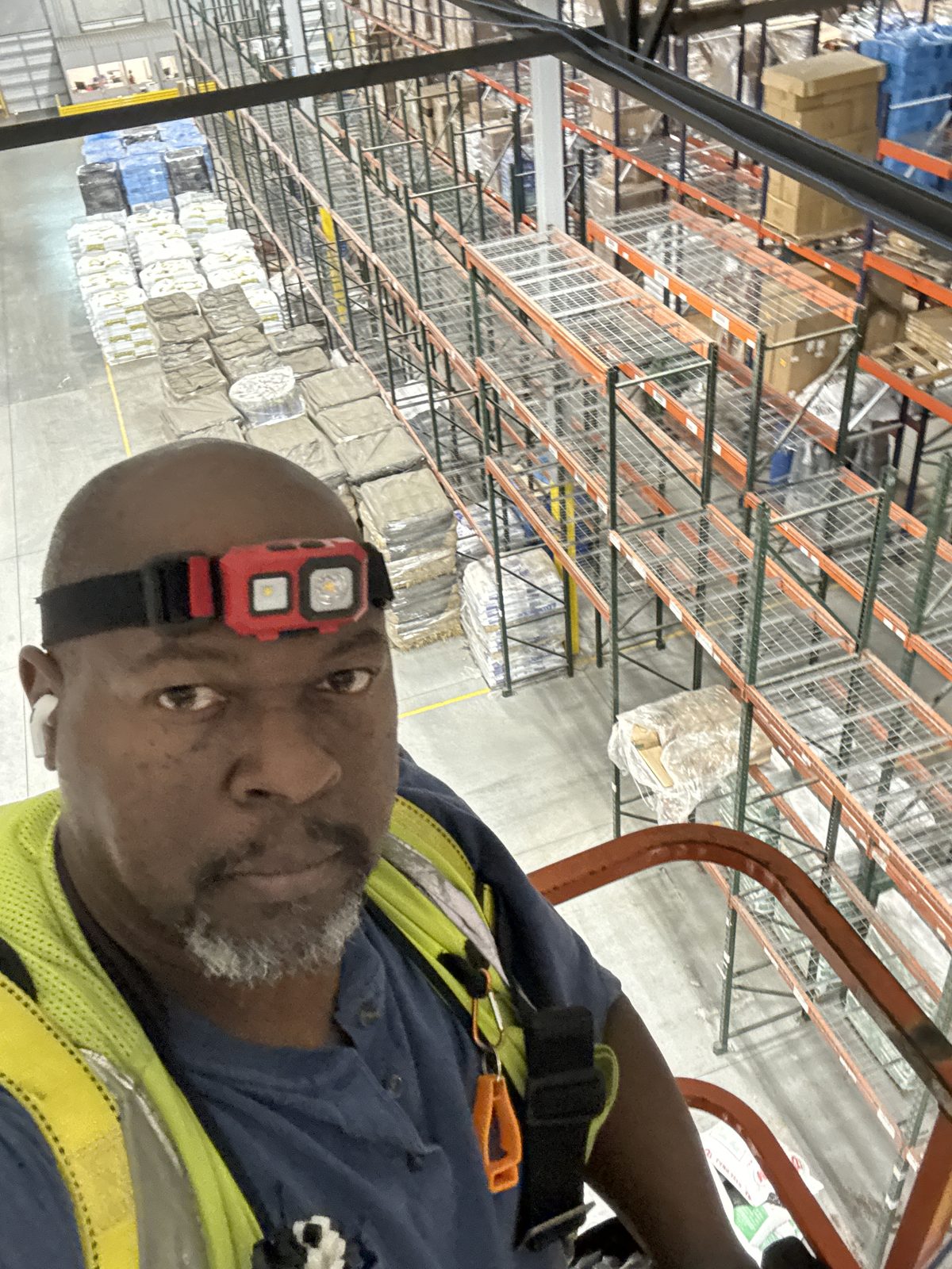 Amos Ross III running overhead cabling on warehouse racking